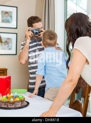 Father Taking Picture Of Birthday Boy And Woman Stock Photo