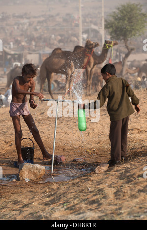 Two boys in the fountain in Pushkar Camel Fair Stock Photo