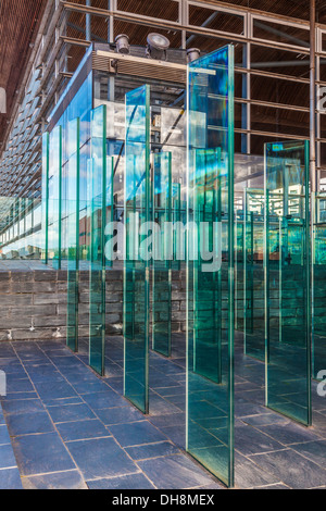 The Assembly Field outside the Senedd in Cardiff Bay Wales. Modern glass panels form a wind break, both functional and artistic. Stock Photo