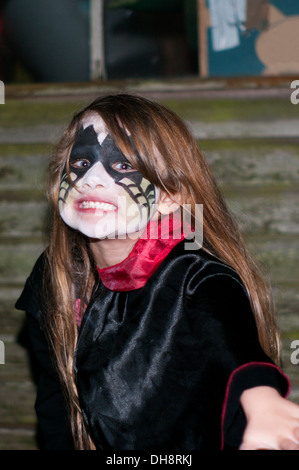 Little Girl Wearing Halloween Face Paint and Costume Pulling an Scary Face Stock Photo