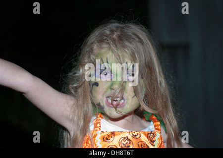 Little Girl Wearing Halloween Face Paint Pulling an Angry Face Stock Photo