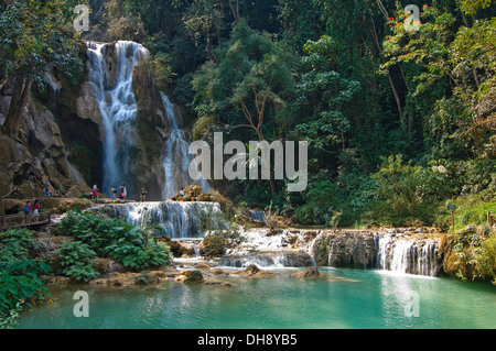 Horizontal view of tourists paddling in the picturesque Kuang Si Falls in Laos. Stock Photo