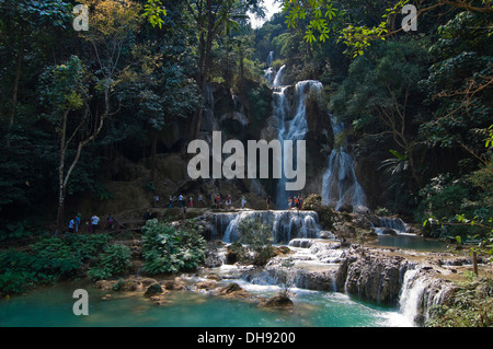 Horizontal view of tourists paddling in the picturesque Kuang Si Falls in Laos. Stock Photo