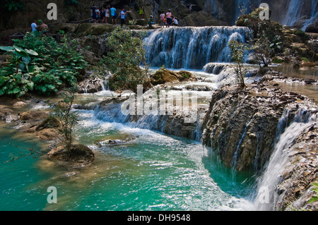 Horizontal view of tourists paddling in the picturesque Kuang Si Falls in Laos. Stock Photo