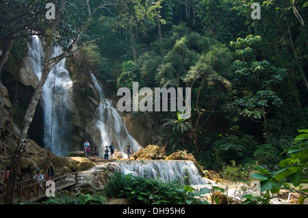 Horizontal view of tourists paddling in the picturesque Kuang Si Falls in Laos. Stock Photo