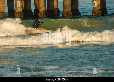 Classic view of a longboard surfer on an early morning Summer swell lit by the rising sun at Manhattan Beach, California. (USA) Stock Photo