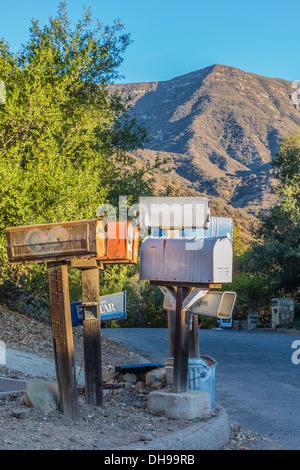 A random grouping of colored and silver US Mailboxes.on a residential street in Ojai, California with mountains in background. Stock Photo