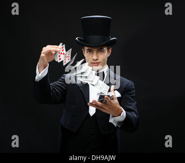 magician showing trick with playing cards Stock Photo