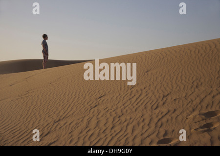 A boy looks out on Liwa Desert, Abu Dhabi in United Arab Emirates Stock Photo