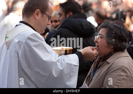 Priest give communion to faithful Stock Photo