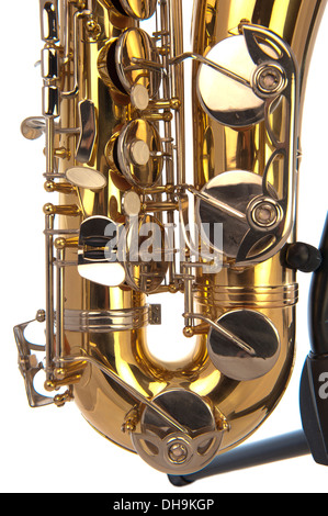 Belly of brass tenor saxophone with silver valves and pearl buttons on a stand in closeup Stock Photo