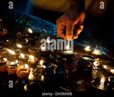 People burning oil lamps as religious ritual in Hindu temple. India Stock Photo