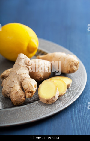 fresh ginger root and lemon on vintage plate Stock Photo