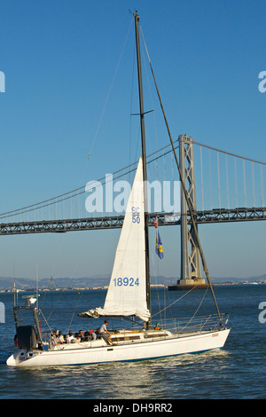 Sailing Yacht, Yukon Jack,  returns with the Bay Bridge in the background, San Francisco. Stock Photo