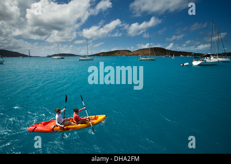 Two people kayaking in bright blue Caribbean waters on a sunny day in British Virgin Islands Stock Photo