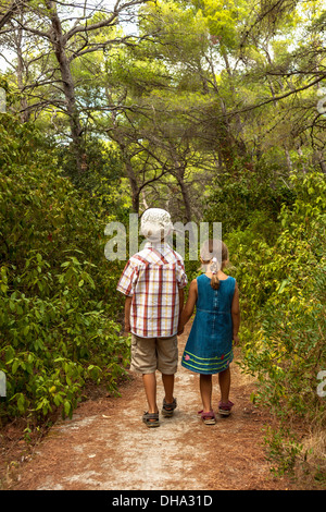 Brother and sister walking in a forest Stock Photo