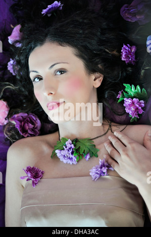 Portrait of a young beautiful woman lying on bed Stock Photo