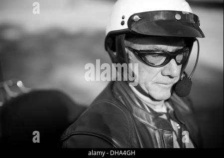Well composed black and white portrait of friendly old biker guy in helmet and goggles, with plenty of negative space for you to Stock Photo
