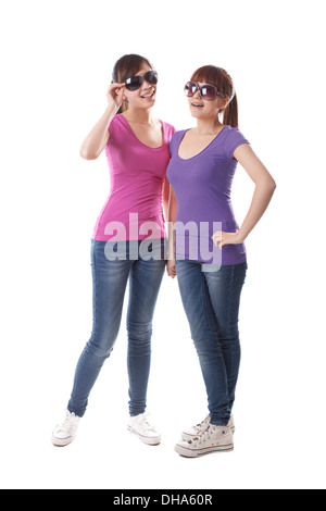 Two young women standing together on white background,wearing sun glasses Stock Photo