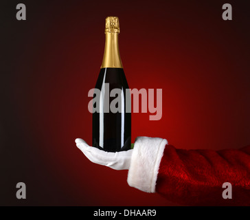 Closeup of Santa Claus holding a bottle of Champagne in the palm of his outstretched hand. Stock Photo