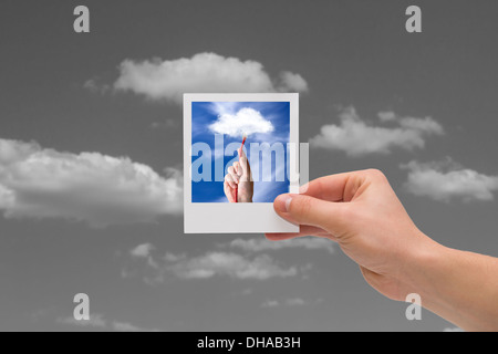 Holding instant cloud photo on a black sky background. Stock Photo