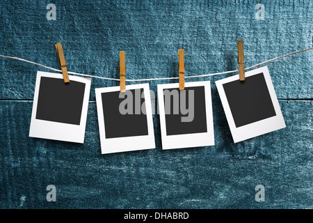 four photo paper attach to rope with clothes pins on wooden background Stock Photo