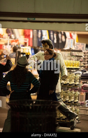 Tourists Pose with a statue of Elvis at a souvenir shop on Hollywood Blvd in Hollywood California Stock Photo