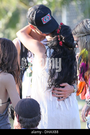 Vanessa Hudgens and Austin Butler sharing a drink and kissing and cuddling while watching a band Celebrities at 2012 Coachella Stock Photo