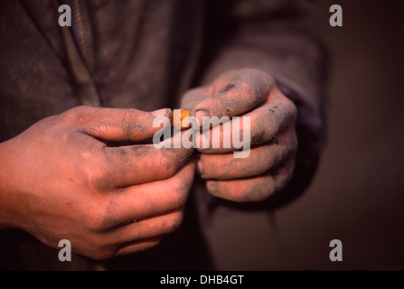 Teenage boy holding amber nodule recovered from the Blue Earth at the Palmnicken amber mine on the Russian Baltic coast. Stock Photo