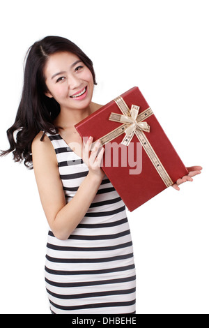 Young woman in a striped dress holding gift box Stock Photo