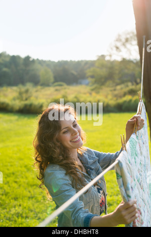 A woman hanging laundry on the washing line, in the fresh air. Stock Photo