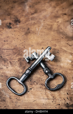Two old fashioned keys lying on vintage wooden table Stock Photo