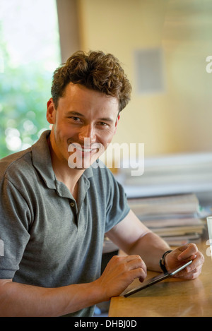 A person sitting alone in a cafe. A  man using a digital tablet. Stock Photo