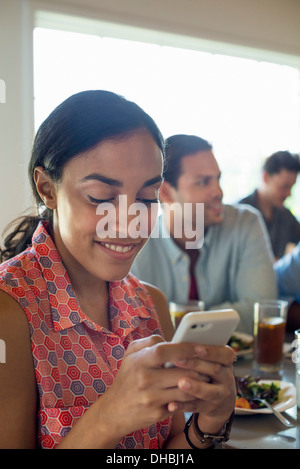 A group of men and women in a cafe, having drinks and enjoying each other's company. Stock Photo