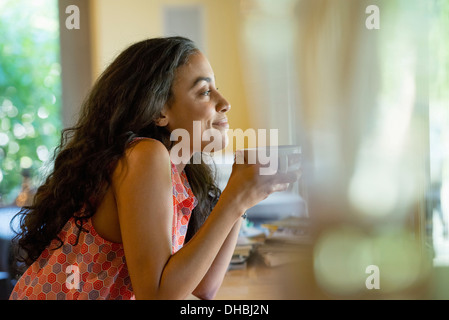 A woman sitting alone in a cafe, having coffee. Stock Photo