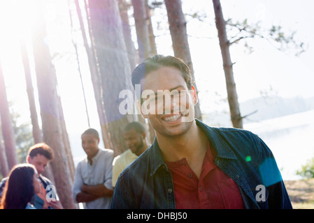 Lakeside.  A  friends gathered in the shade of pine trees in summer. Stock Photo
