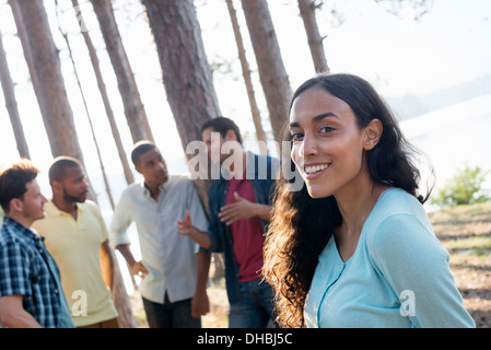 Lakeside.  A  friends gathered in the shade of pine trees in summer. Stock Photo