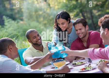 A group of people having a meal outdoors, a picnic. Men and women. Stock Photo