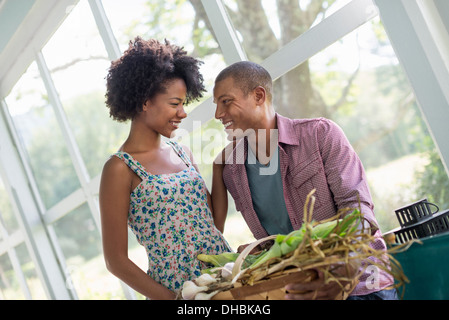 A couple at a table in a farmhouse, flirting and laughing. Stock Photo