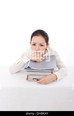 Tired indian woman sitting at desk and reading book Stock Photo - Alamy