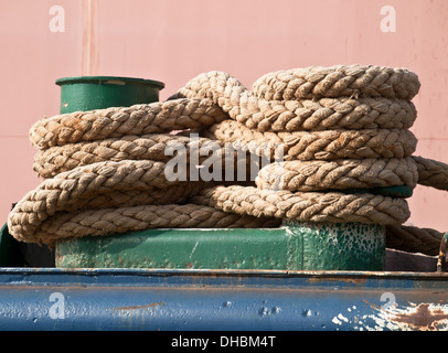 green mooring bollard and bundle of rope Stock Photo