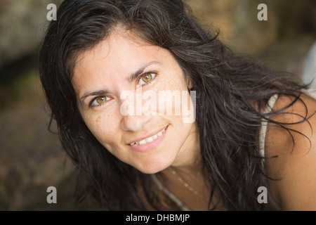 Close up of a smiling woman with freckles on her face. Stock Photo