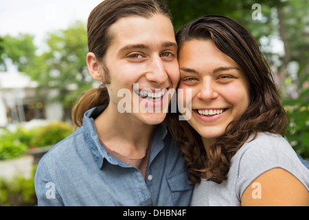 A young couple side by side, flirting and taking photographs. Stock Photo