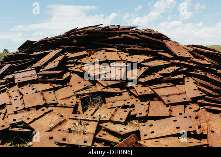 A large pile of rusty plates, used for railroad construction. Discarded or piled up for recycling. Stock Photo