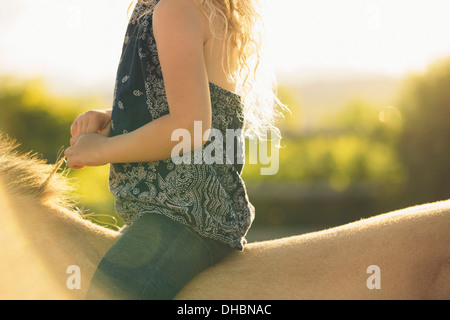 A young girl sitting on a horse. Stock Photo