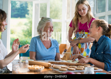 Farmhouse in the country in New York State. Four generations of women in a family baking together. Stock Photo
