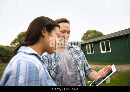 An organic farm in the Catskills. Two people using a digital tablet outdoors. Stock Photo