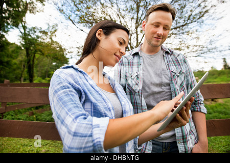 An organic farm in the Catskills. Two people looking at the screen of a digital tablet. Stock Photo