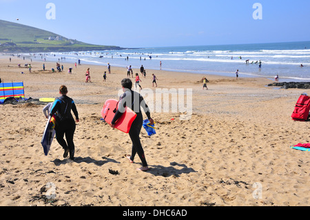 Surfers and holidaymakers on the beautiful golden sand surfing beach at Croyde Bay, Devon, England in springtime