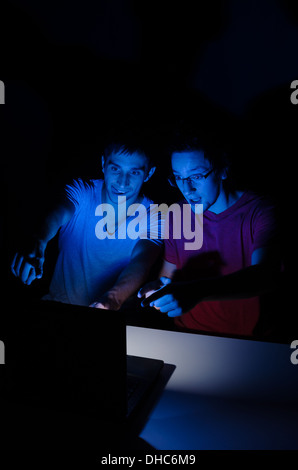 Two guys in front of a computer screen getting all excited about ...